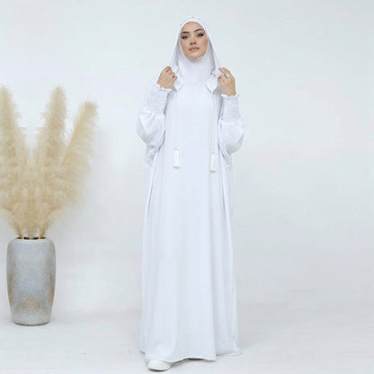 White hooded prayer dress, front view, voluminous silhouette with braided tassel ties